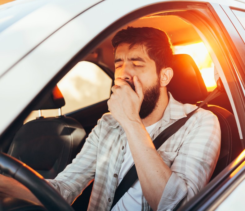 Ein Mann gähnt im Auto. Ein Mann gähnt im Auto.