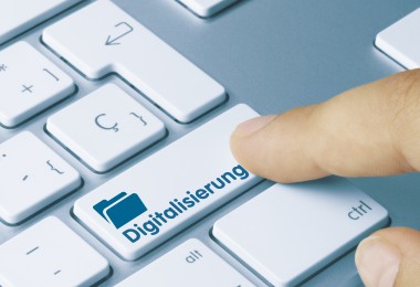 Eine Nahaufnahme einer Computertastatur mit einer speziellen Taste, auf der das Wort „Digitalisierung“ und ein Symbol eines Ordners abgebildet sind. Eine Fingerkuppe drückt die Taste, was den Prozess der digitalen Transformation symbolisiert. Eine Nahaufnahme einer Computertastatur mit einer speziellen Taste, auf der das Wort „Digitalisierung“ und ein Symbol eines Ordners abgebildet sind. Eine Fingerkuppe drückt die Taste, was den Prozess der digitalen Transformation symbolisiert.