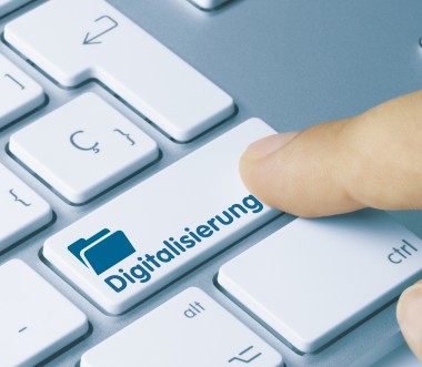 Eine Nahaufnahme einer Computertastatur mit einer speziellen Taste, auf der das Wort „Digitalisierung“ und ein Symbol eines Ordners abgebildet sind. Eine Fingerkuppe drückt die Taste, was den Prozess der digitalen Transformation symbolisiert. Eine Nahaufnahme einer Computertastatur mit einer speziellen Taste, auf der das Wort „Digitalisierung“ und ein Symbol eines Ordners abgebildet sind. Eine Fingerkuppe drückt die Taste, was den Prozess der digitalen Transformation symbolisiert.