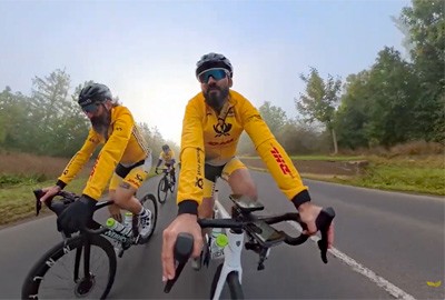 Zwei Fahrer auf Rennrädern. In de mitte der Interviewe, links von ihm Jan Wiedemann. Beide in gelben Trikot. Bei genauem Hinsehen: Wiedemanns linker Arm ist eine Prothese.