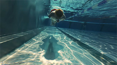 Unterwasser-Aufnahme, bei der Josia Topf auf uns zugeschwommen kommt. Topf hat sehr kurze Gliedmaßen.